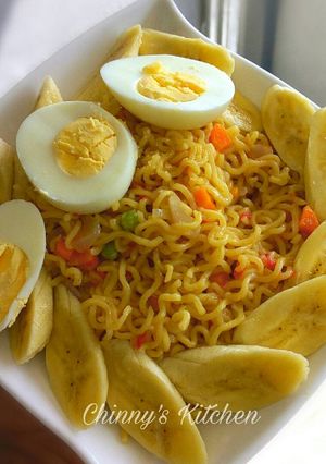 A picture of Stir fry noodles paired with egg and banana.