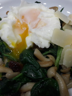 Una foto de Wok de espinacas y shimeji con huevo poché