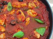 Une photo de poulet aux olives et tomate
