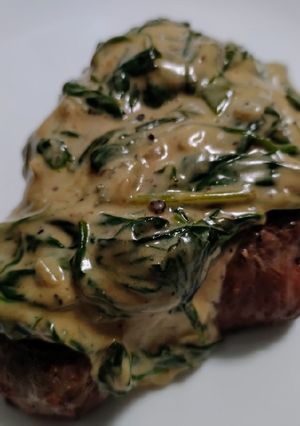 A picture of Steak with gorgonzola and spinach.