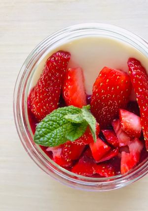 Une photo de Panacotta aux fraises avec coulis de framboises