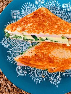 Una foto de Sándwich doradito de york, aguacate y rúcula