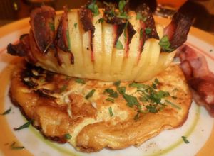 Una foto de Papas abanico con panceta sobre una base de soufflé con paprika
