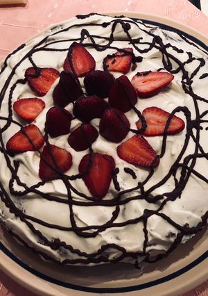 Una foto de Torta postre de chocolate con crema chantilly y frutillas