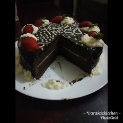 A picture of Chocolate cake with chocolate ganache and whipped cream icing.