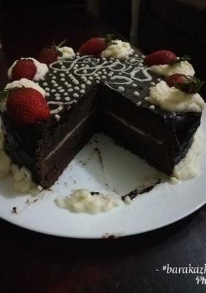 A picture of Chocolate cake with chocolate ganache and whipped cream icing.