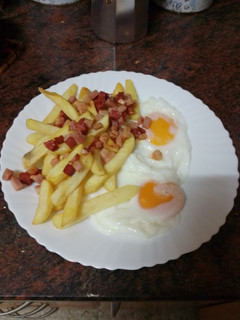 Una foto de Huevos fritos con papas fritas y picada de chorizo y bacon
