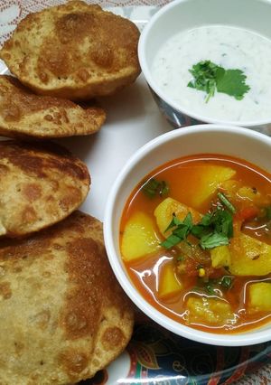 A picture of Ajwain ki Poori with Aloo Tamatar Sabzi.