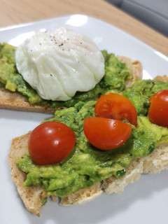 Una foto de Tosta de aguacate con huevo poché y tomates cherry