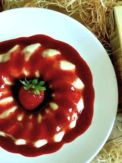 Una foto de Panacotta de horchata con salsa de fresas