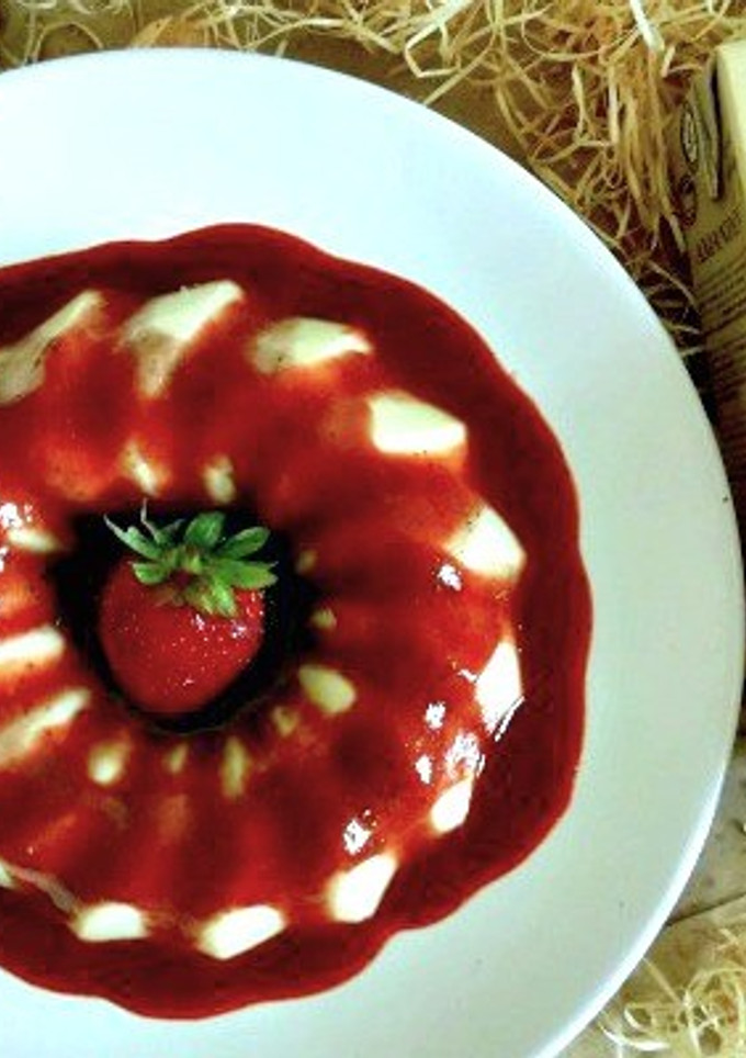 Una foto de Panacotta de horchata con salsa de fresas