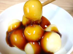 A picture of Japanese dessert Mochi with sweet soy starchy sauce.