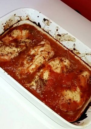 A picture of Chicken breast in a tomato and herb sauce.