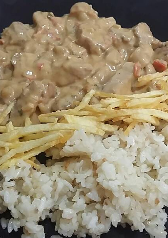 Una foto de Solomillo en salsa patatas chips y arroz