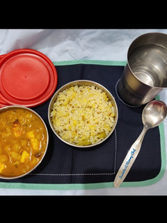 A picture of Hing khichdi with white peas, potato and paneer curry.
