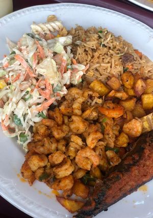 A picture of Rice excurted by shrimps, plantain and salad and mackerel.
