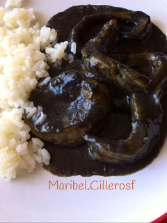 Una foto de Anillas de calamar en su tinta, con guarnición de arroz blanco