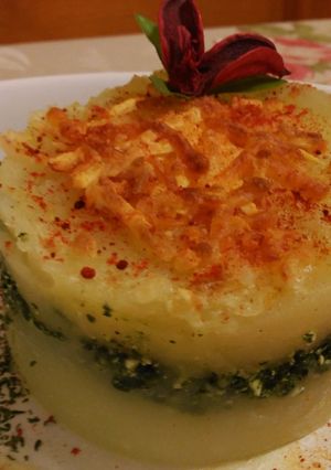 Una foto de Pastel de patatas con espinacas y ricota, bajo esquirlas de parmesano