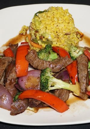 Una foto de Lomo saltado con brócoli y pimiento morrón rojo
