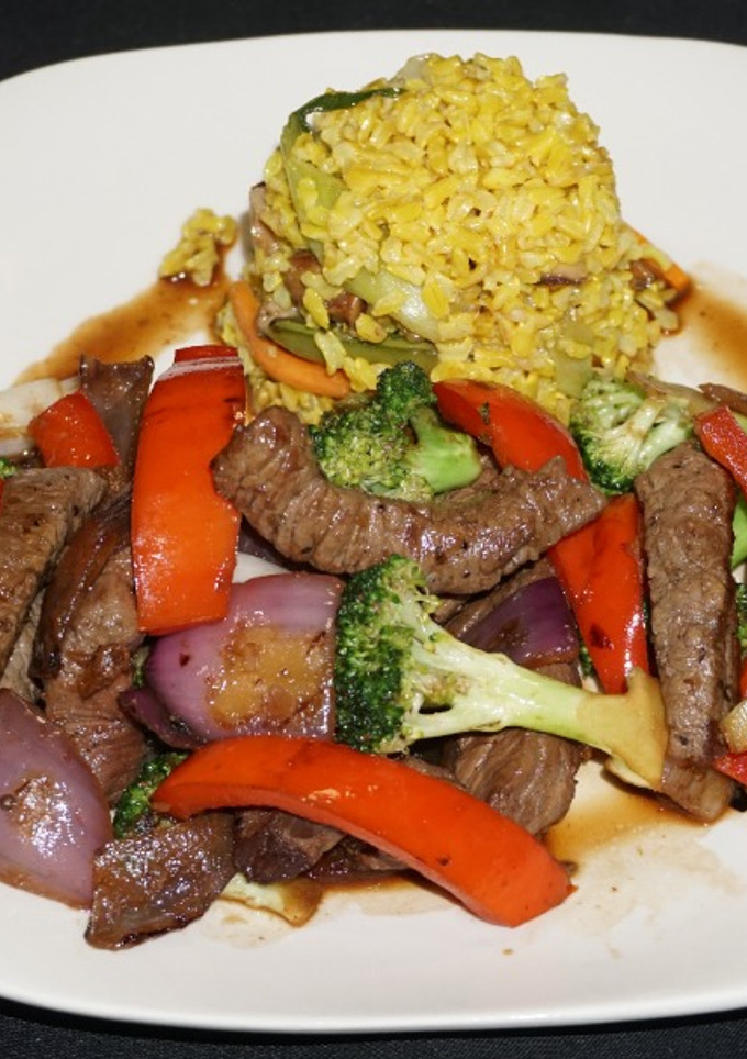 Una foto de Lomo saltado con brócoli y pimiento morrón rojo
