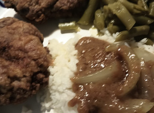 A picture of Chicken Fried Hamburger Steak and an Onion Gravy.