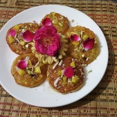 A picture of Pineapple Malpua in Gulab Chashni.