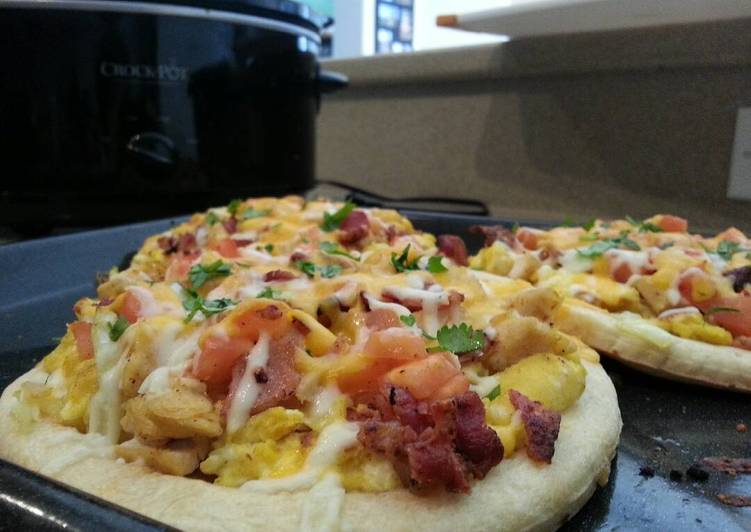Breakfast pizza topped with eggs, chicken,applewood bacon, carme