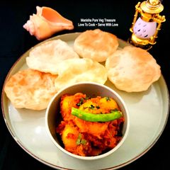 A picture of Phulko Luchi Ar Aloor Dom - Bengali Classic Dish - Dum Aloo With Puffed Fluffy Maida Puri.