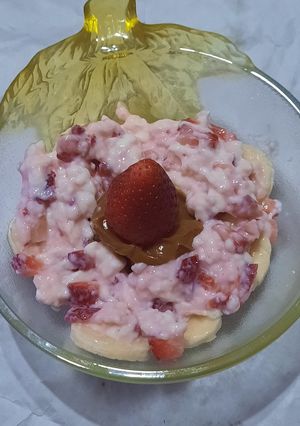 Una foto de Frutillas con banana y crema rosa