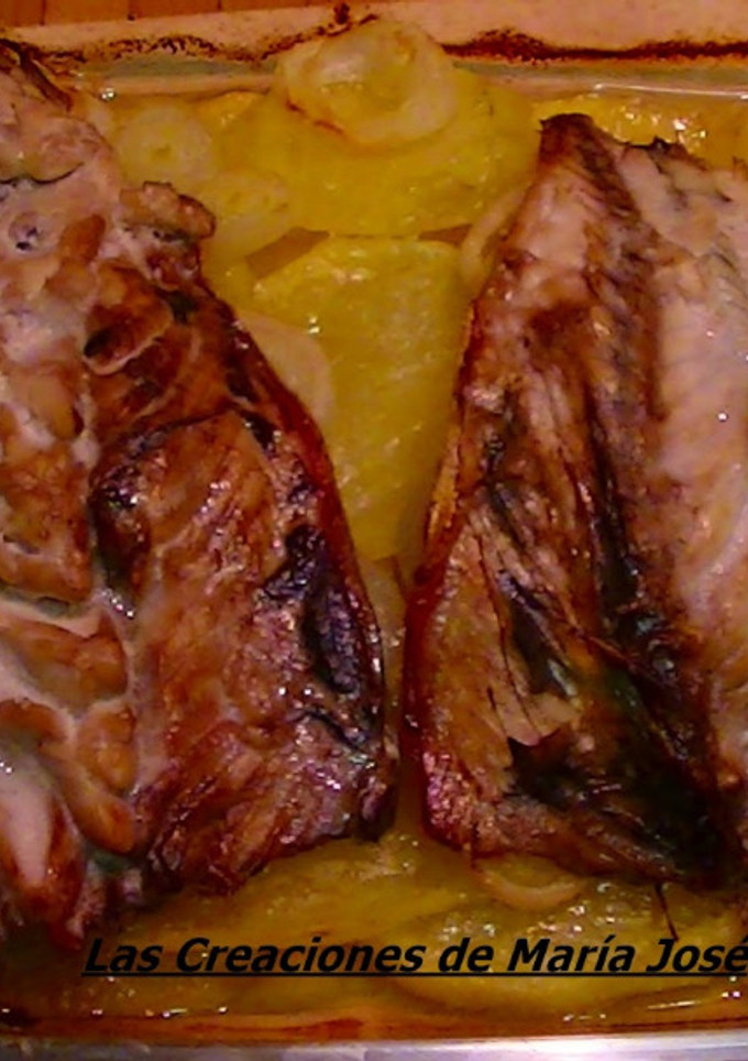 Una foto de Caballa al horno sobre cama de patatas y cebolla