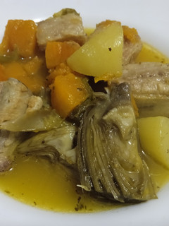 Una foto de Costilla con alcachofas y calabaza