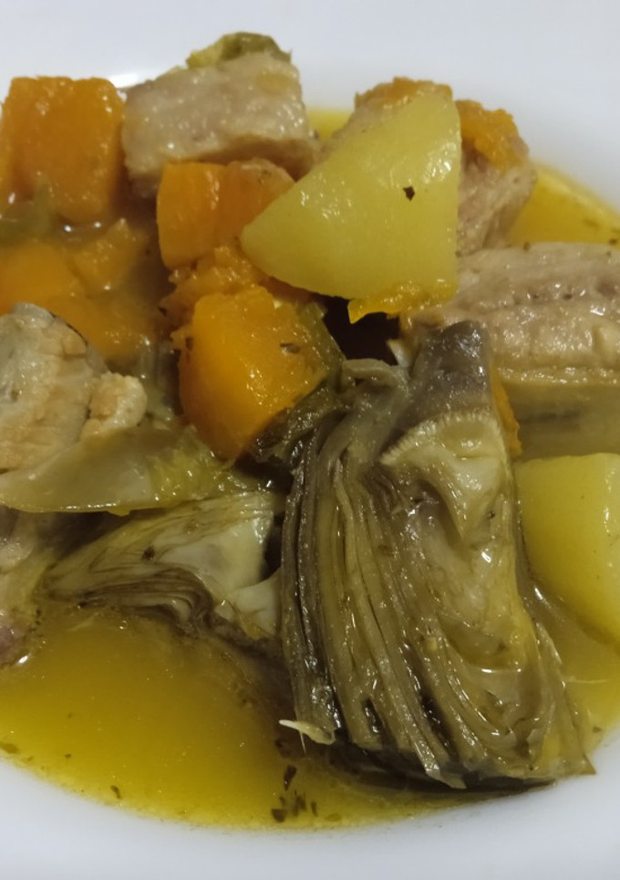 Una foto de Costilla con alcachofas y calabaza