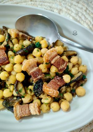 Una foto de Salteado de garbanzos con setas shiitake al curry y torreznos