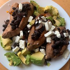 A picture of Black bean, avocado and feta stuffed sweet potatoes (vegetarian).