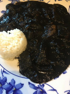 Una foto de Calamares en su tinta con arroz blanco