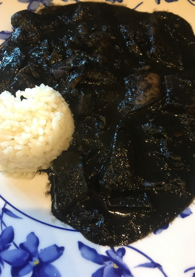 Una foto de Calamares en su tinta con arroz blanco
