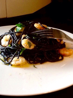 Una foto de Spaguetti nero di sepia con gambas al ajillo