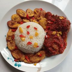 A picture of Rice, fried plantain and stew.