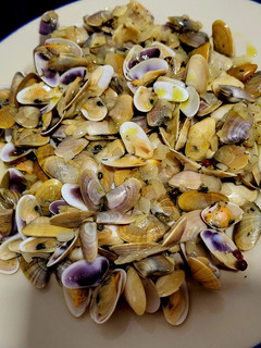 Una foto de Tellinas, con cebolla caramelizada y sake