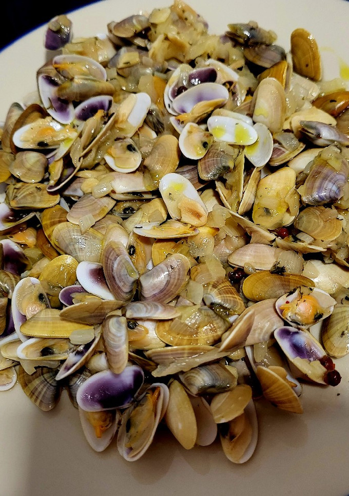 Una foto de Tellinas, con cebolla caramelizada y sake