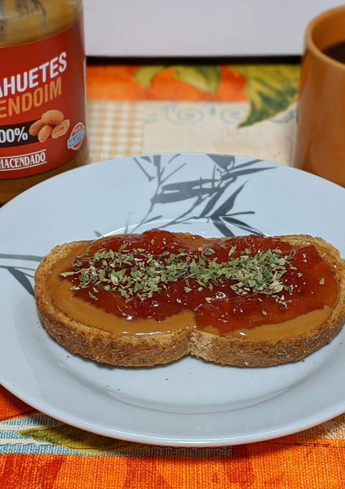 Una foto de Tostada integral con crema de cacahuete, mermelada de tomate y orégano