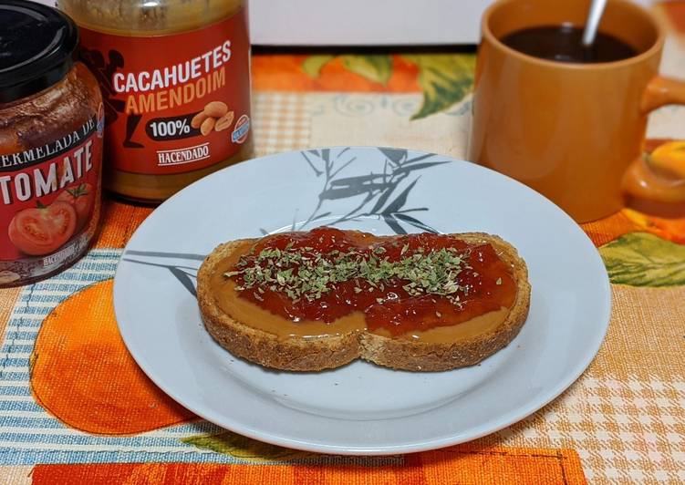 Tostada integral con crema de cacahuete, mermelada de tomate y orégano