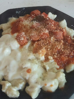 Una foto de Ñoquis de papa con salsa roja y blanca