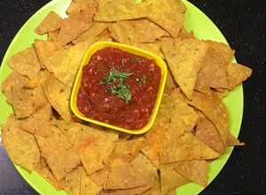 A picture of Nachos with Tomato Salsa.