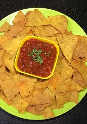 A picture of Nachos with Tomato Salsa.