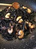 Tagliolini al nero di seppia gamberi saltati cipolla rossa di Tropea e basilico