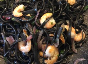 Foto di Tagliolini al nero di seppia gamberi saltati cipolla rossa di Tropea e basilico