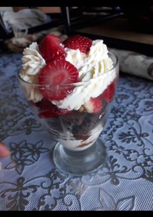 Una foto de Postre en copa de crema doble y frutillas