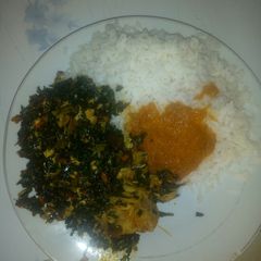 A picture of Rice and ugu sauce.