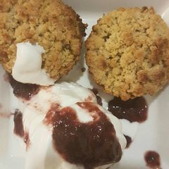 A picture of Apple crumble with vanilla ice cream and cranberry sauce.